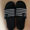 Bequeme schwarze Badeschlappen / Schlappen mit Streifen