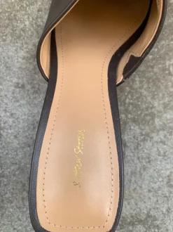 Clogs in Braun mit Preisetikett