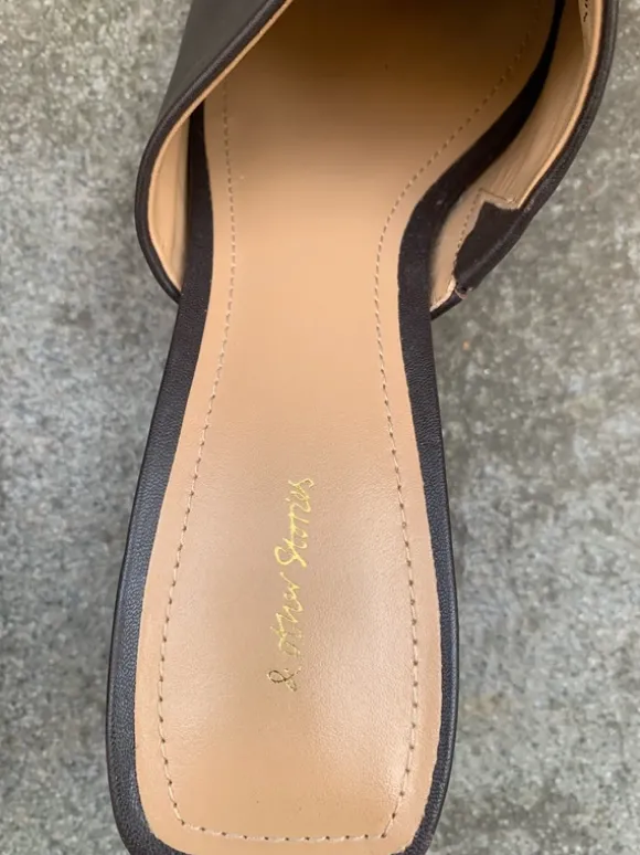 Clogs in Braun mit Preisetikett