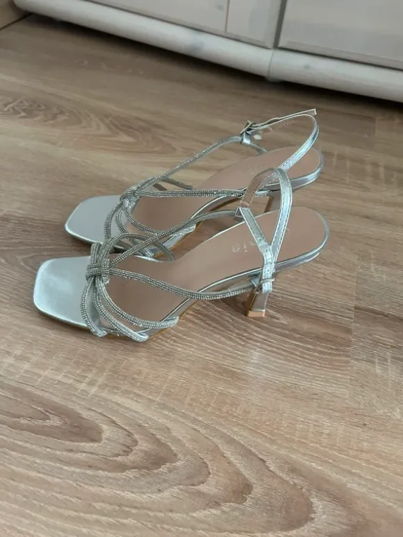 Elegante silberfarbene High Heels mit funkelnden Strassriemen