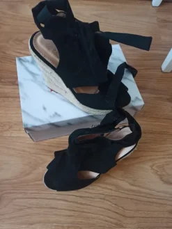 Schwarze Keilschuhe zum Schnüren.